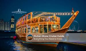 Dubai Dhow Cruise sailing along the waterfront with illuminated skyline views at sunset.